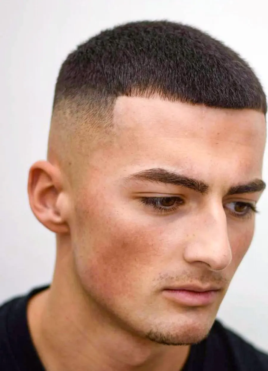Buzz cut side profile with clean edge-up and taper.